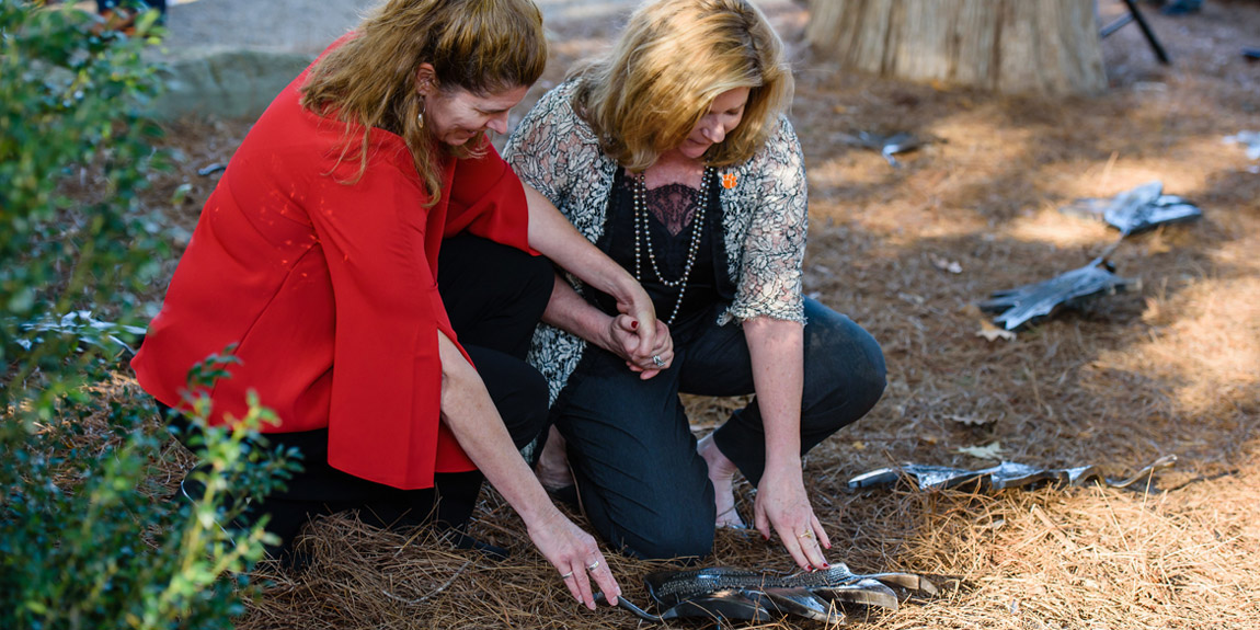 Samuel Deal's daughters look at his bronze oak leaf on the ground at Fort Hill.